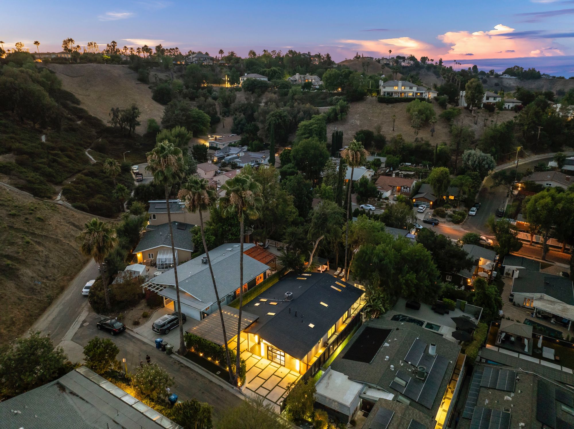 Glass-walled wine cellar tucked off the main living volume, lit at low intensity.