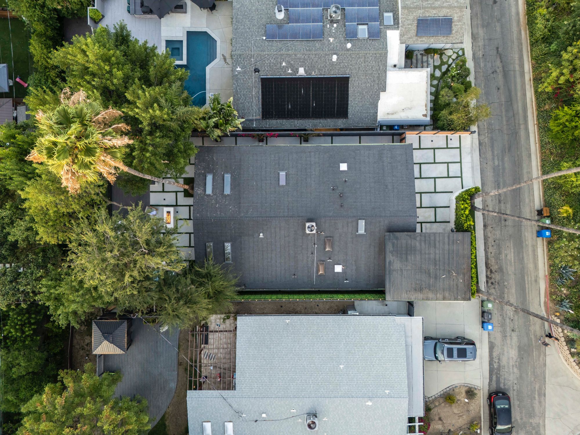 Rear elevation by night, illuminated pool reflecting the rebuilt facade and clerestory windows.